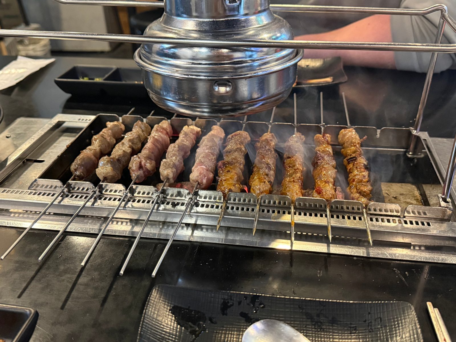 숯불 위에 한 줄로 걸려 익고 있는 양꼬치