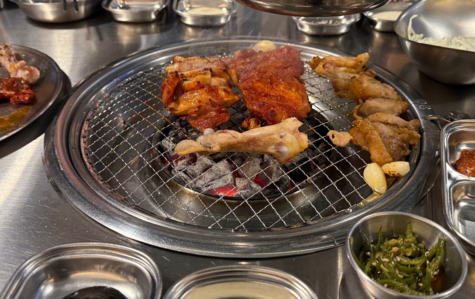 숯불 석쇠 위에서 익고 있는 소금닭갈비와 고추장닭갈비