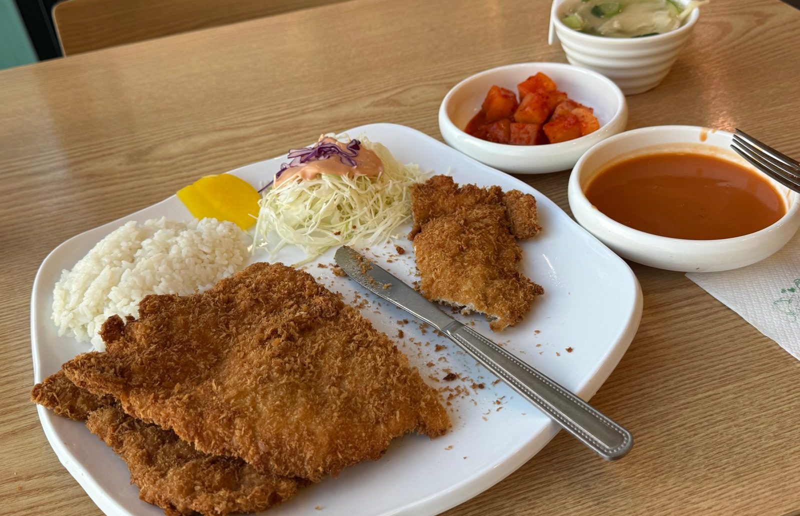 흰 접시에 밥과 양배추와 함께 담긴 큼직한 경양식 돈까스