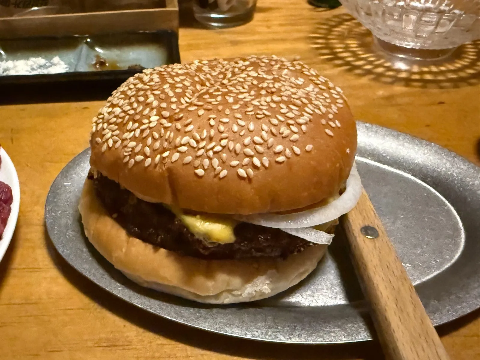 철제 접시에 놓인 참깨빵 치즈버거