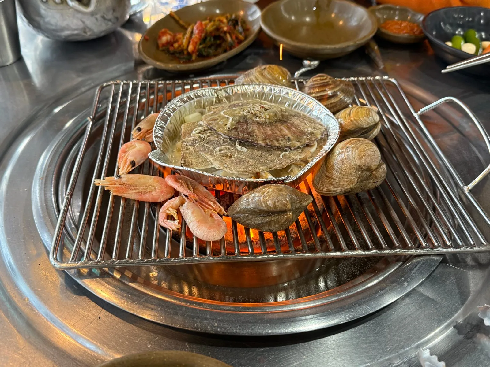 숯불 석쇠 위에 올린 조개와 새우, 은박 그릇