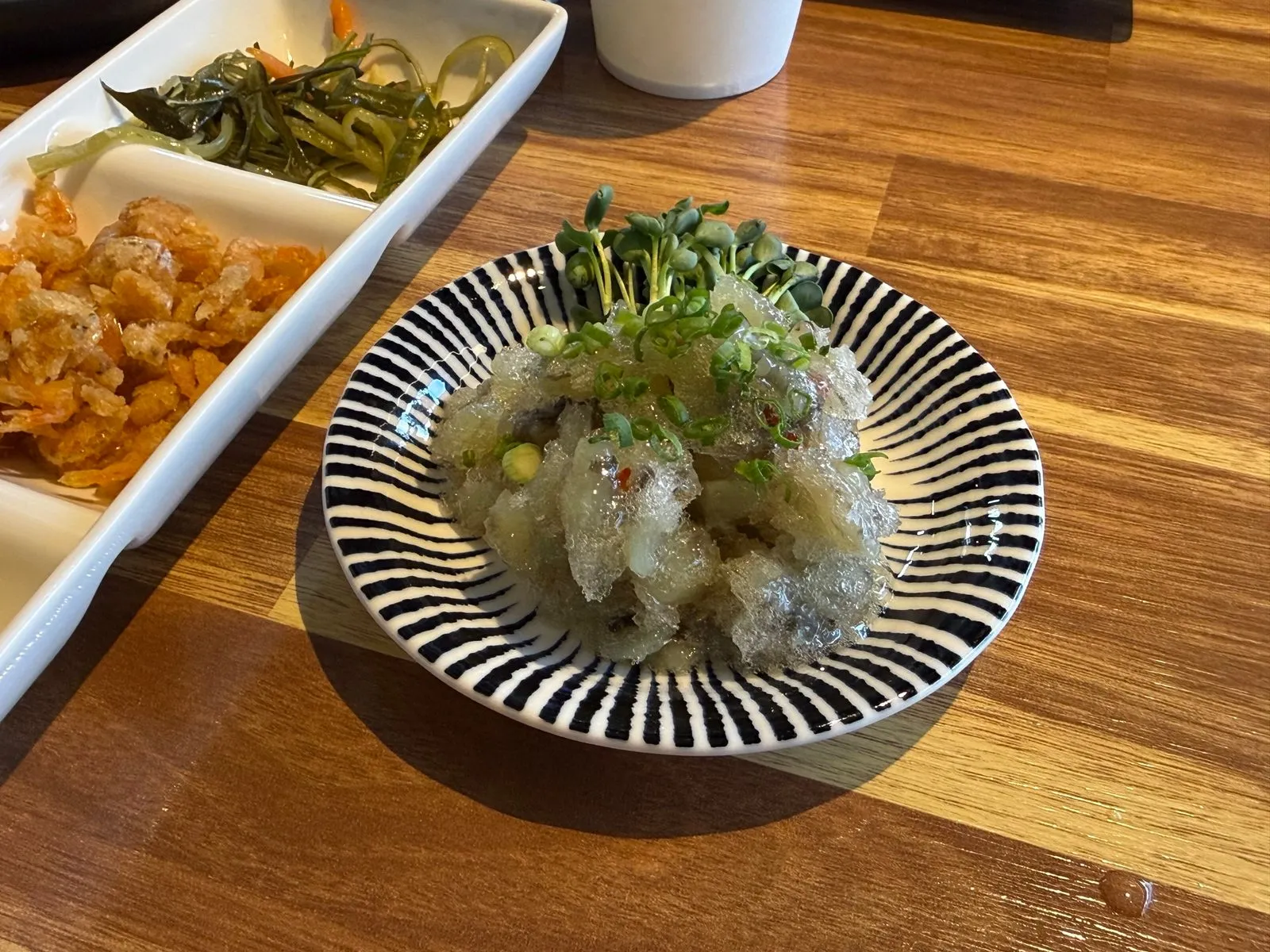줄무늬 그릇에 담긴 타코와사비와 그 위에 올린 새싹