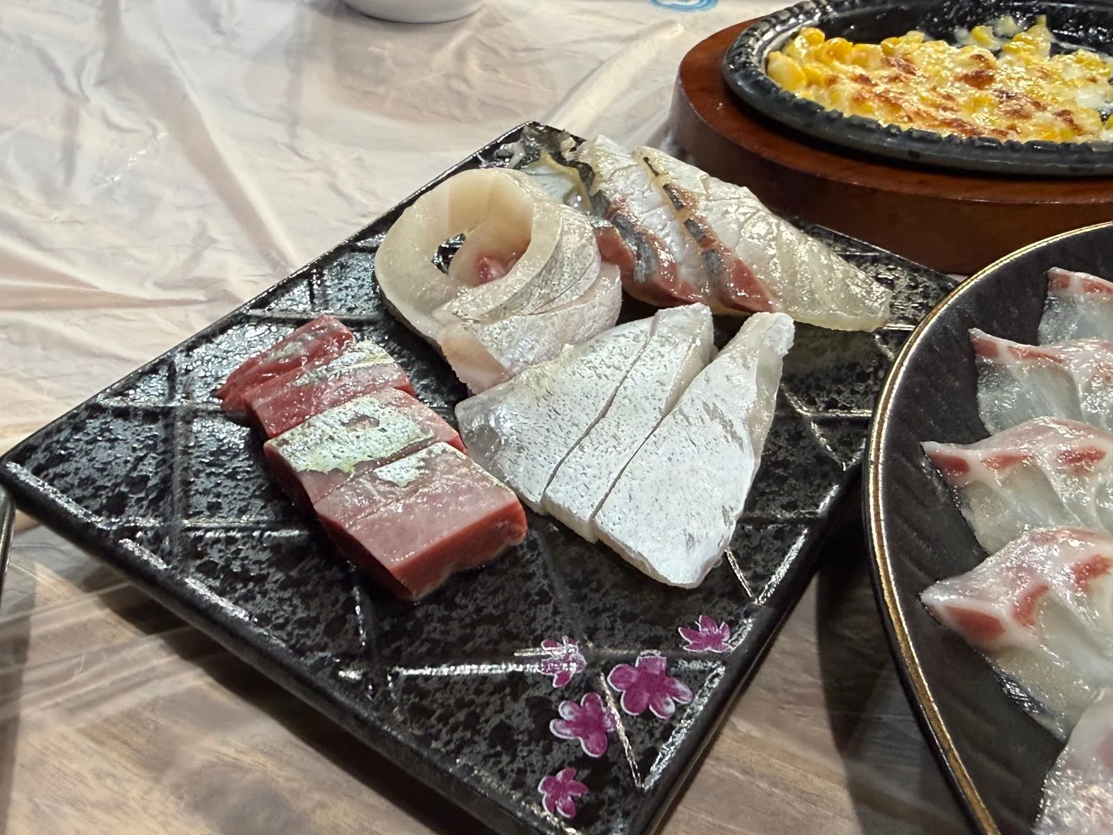 무늬가 있는 네모난 접시에 담긴 생선 특수부위 몇 점