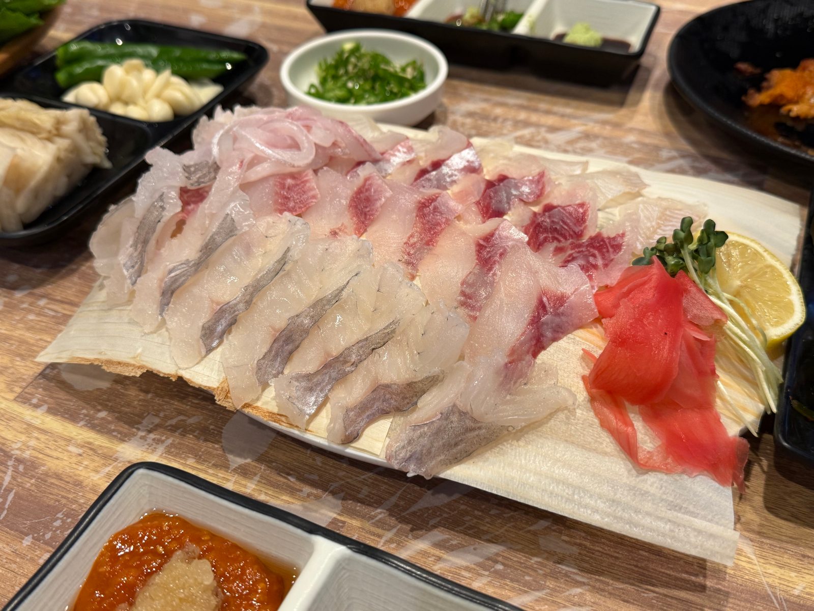 큰 접시에 여러 가지 생선회를 펼쳐 담은 모듬회
