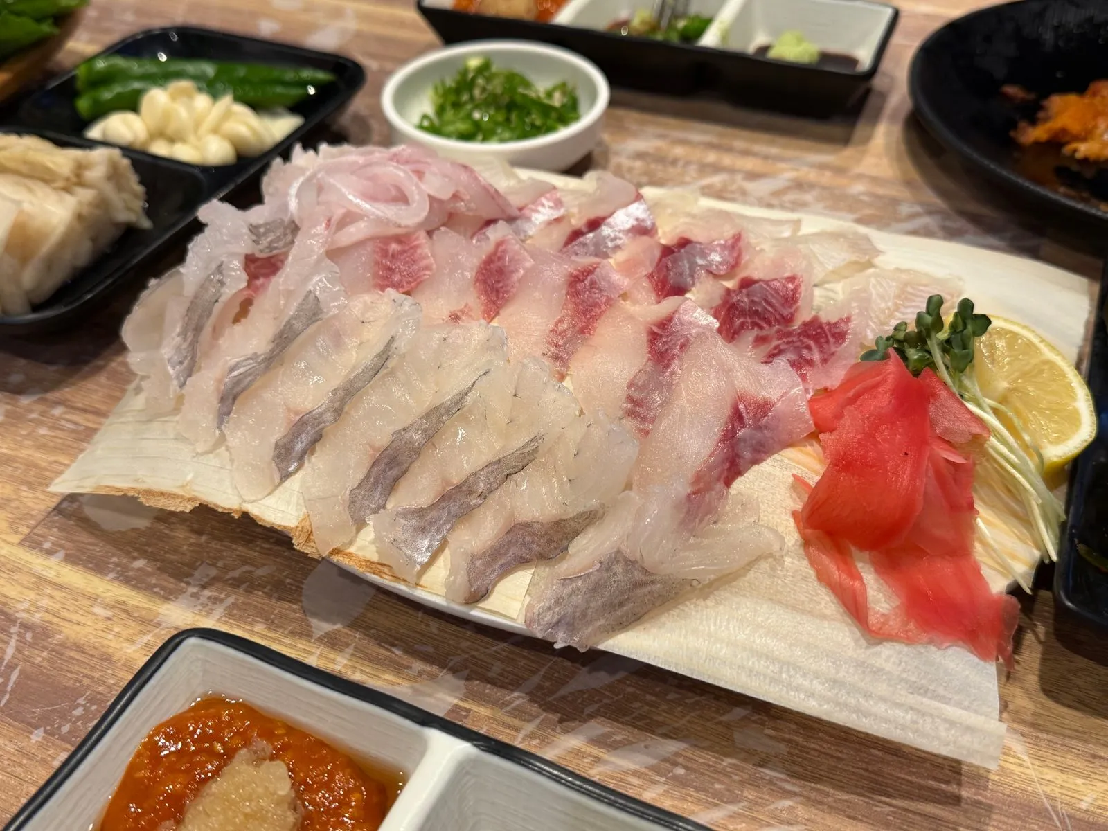 큰 접시에 여러 가지 생선회를 펼쳐 담은 모듬회