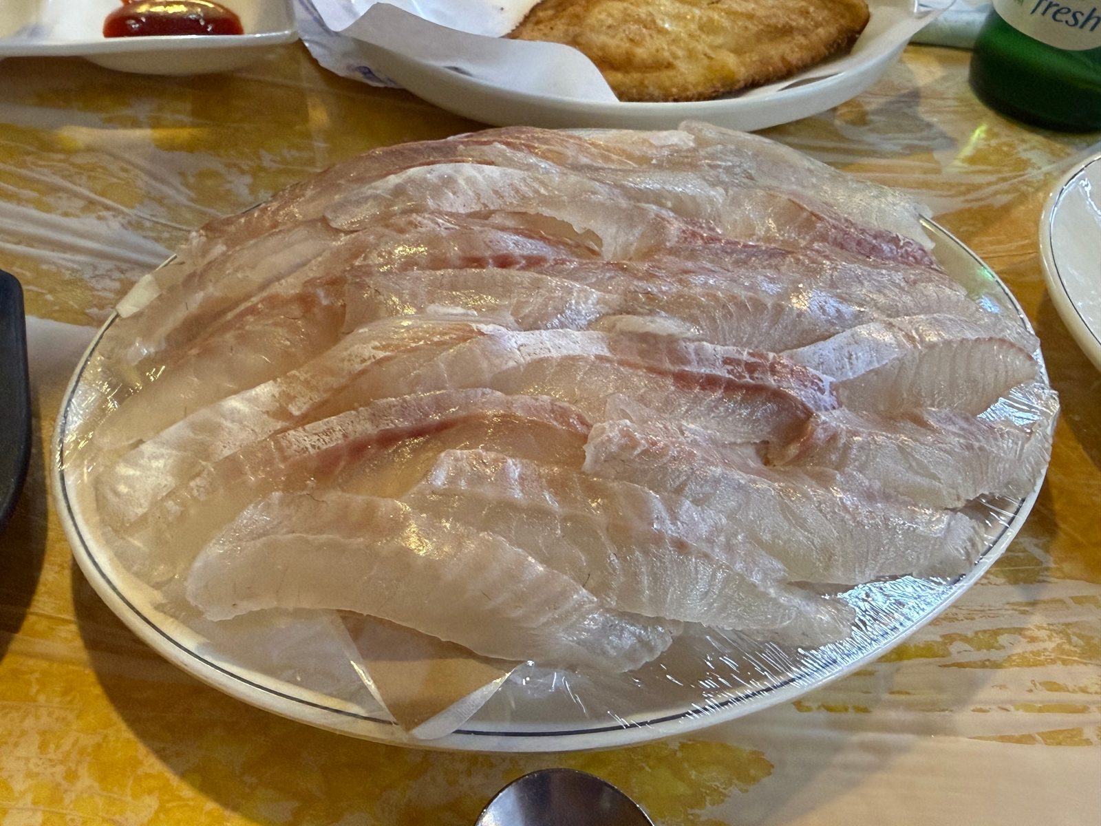 넓은 접시에 얇게 떠서 가지런히 놓은 흰살 생선회