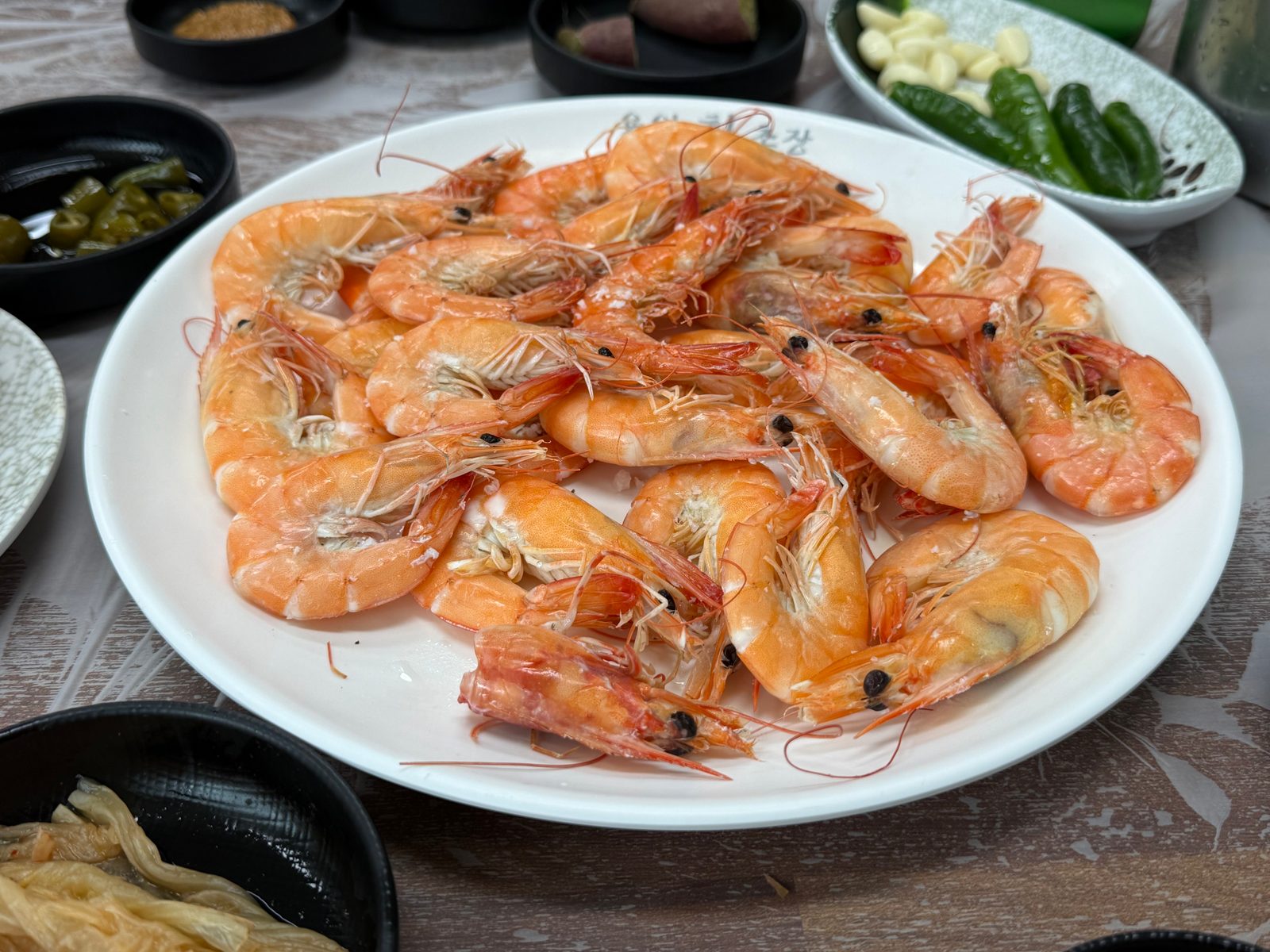 흰 접시에 가득 담긴 소금구이 새우