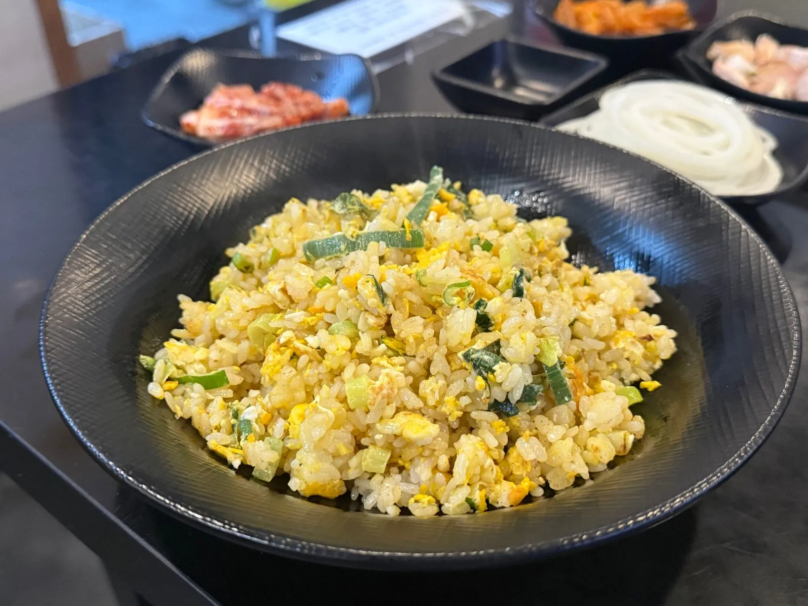 검은 그릇에 담긴 노란 계란볶음밥