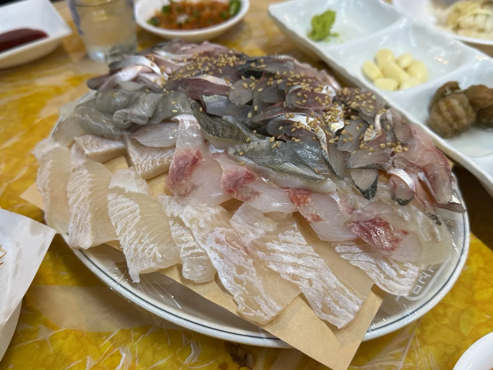 큰 접시에 전어와 흰살 생선회를 함께 담은 모듬회