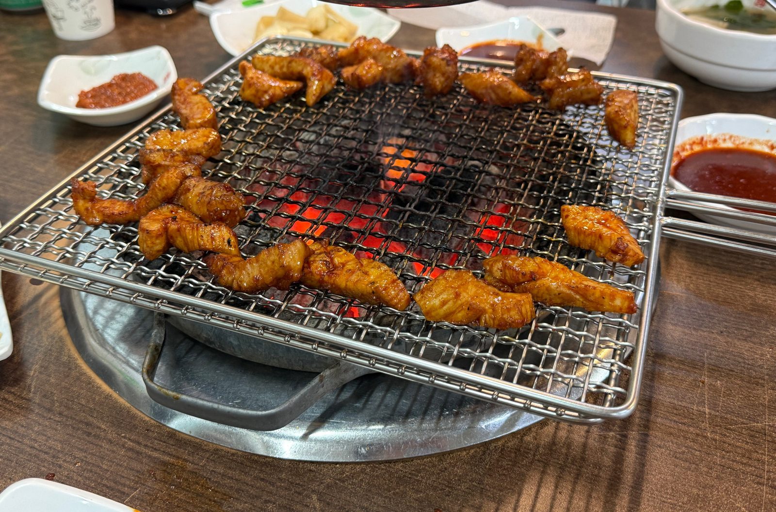 숯불 위 석쇠에서 익고 있는 양념한 특양과 대창