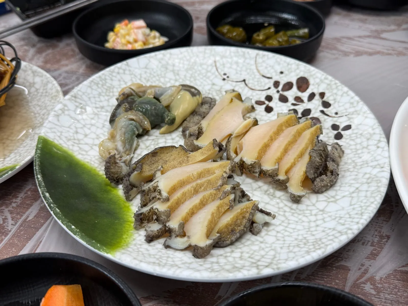 접시에 담아 낸 전복과 초록빛 양념
