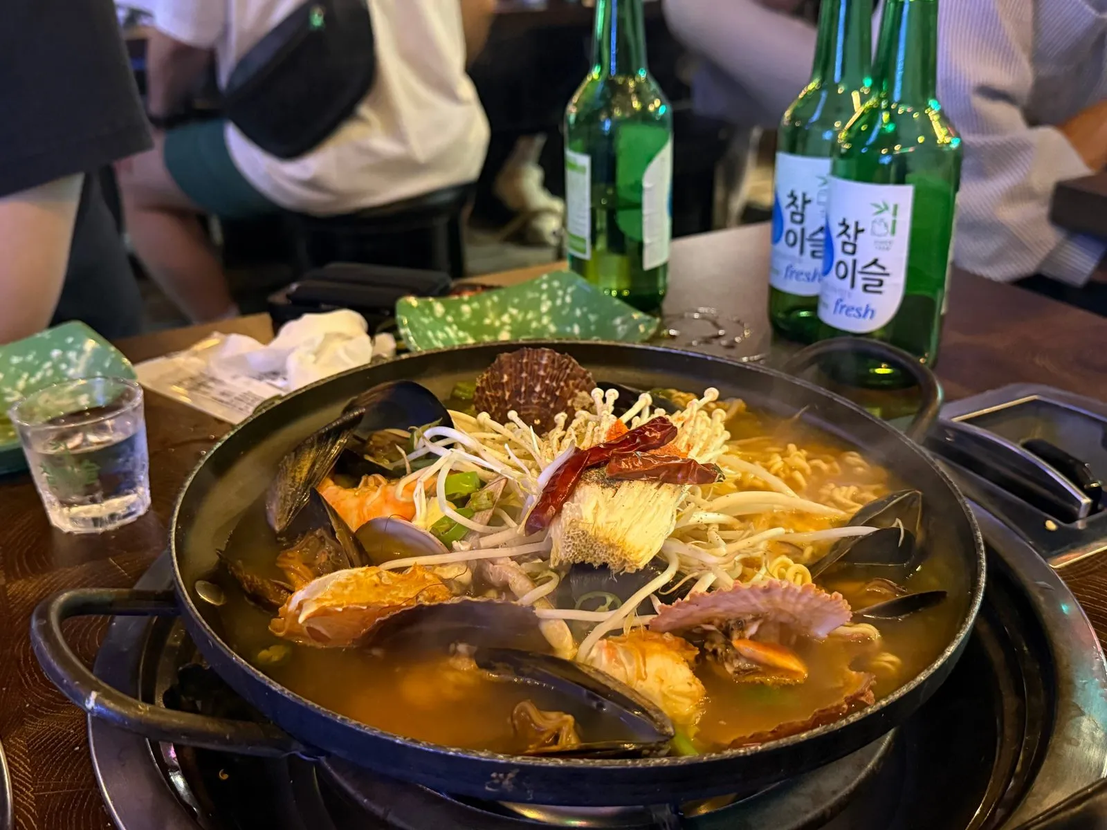 홍합과 콩나물이 올라간 냄비 라면과 소주병