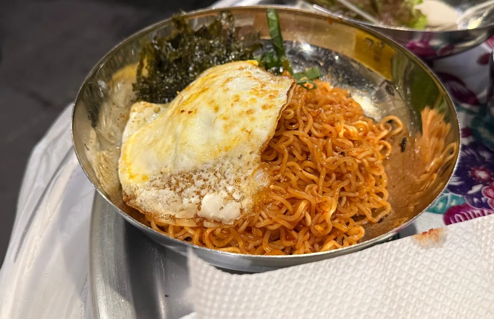 양은 그릇에 담긴 비빔면과 그 위에 올린 달걀프라이와 김