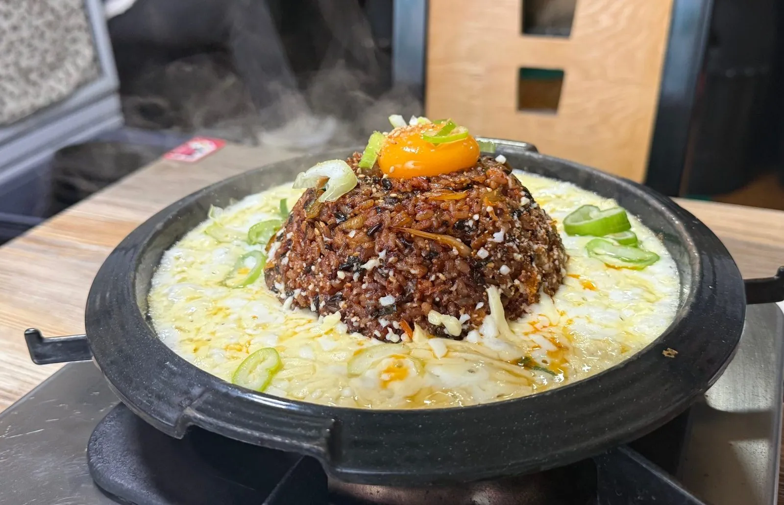 돌판 위에 치즈와 계란 노른자를 얹은 볶음밥